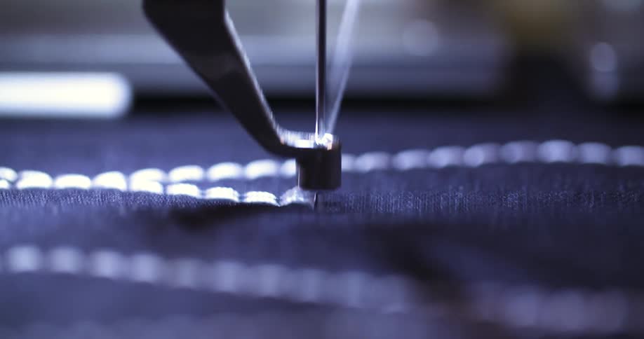 Sewing machine needle makes a line of stitches while creating a pattern on fabric
