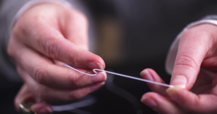 The woman threads the needle