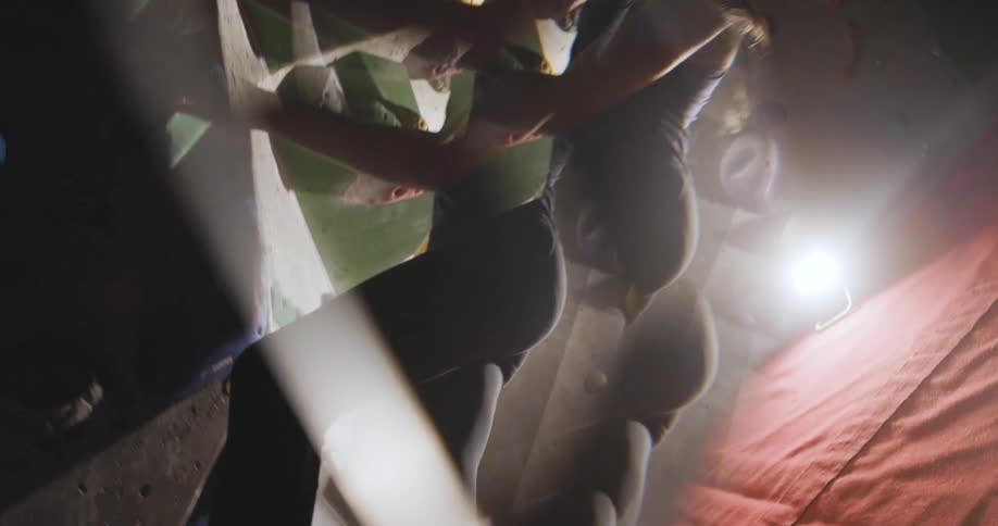 Young woman climbing a rocky indoor wall