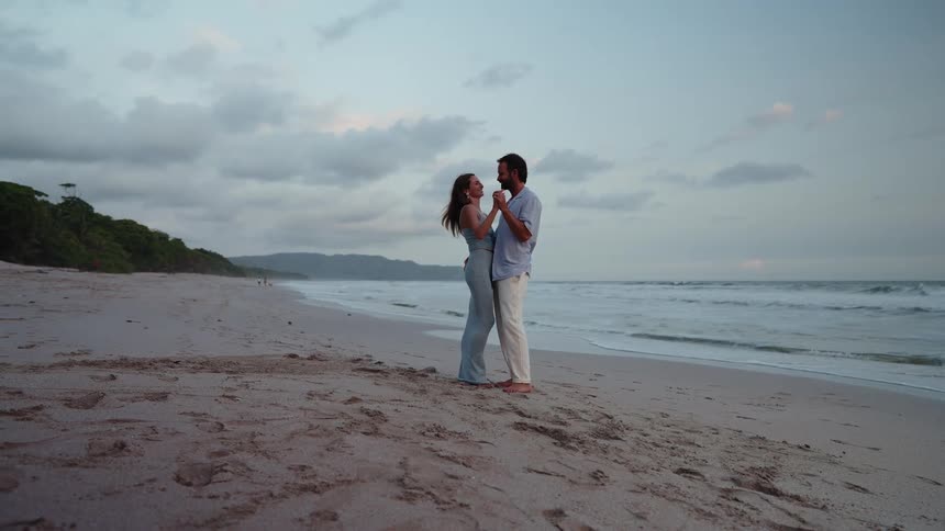 The couple are dancing on the beach