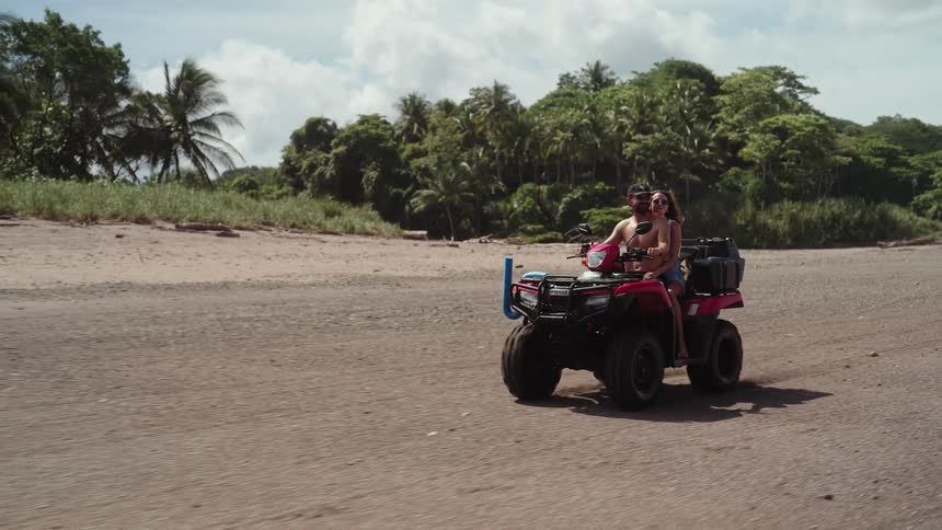 Couple hugging riding buggy on tropical beach