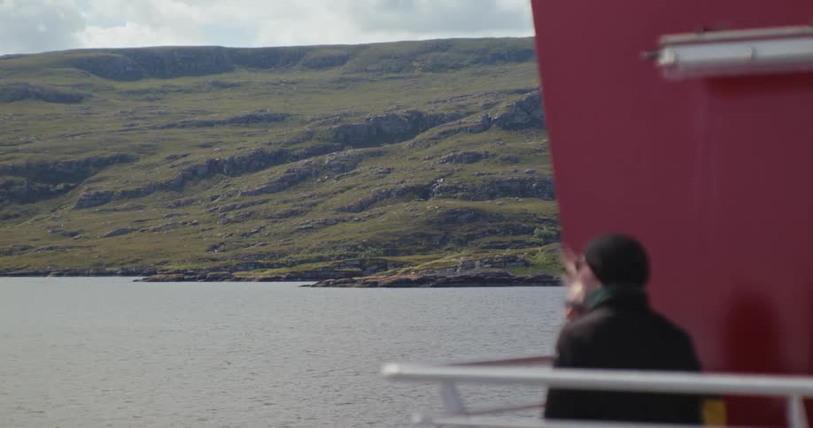 Man and woman watching the mountainous landscape from the vessel