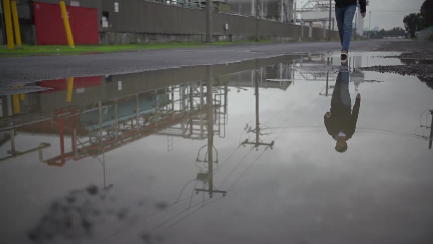 Person walking over a puddled road