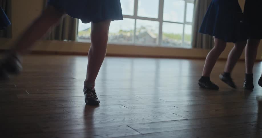 A group of young girls dancing ballet in a dance studio setting