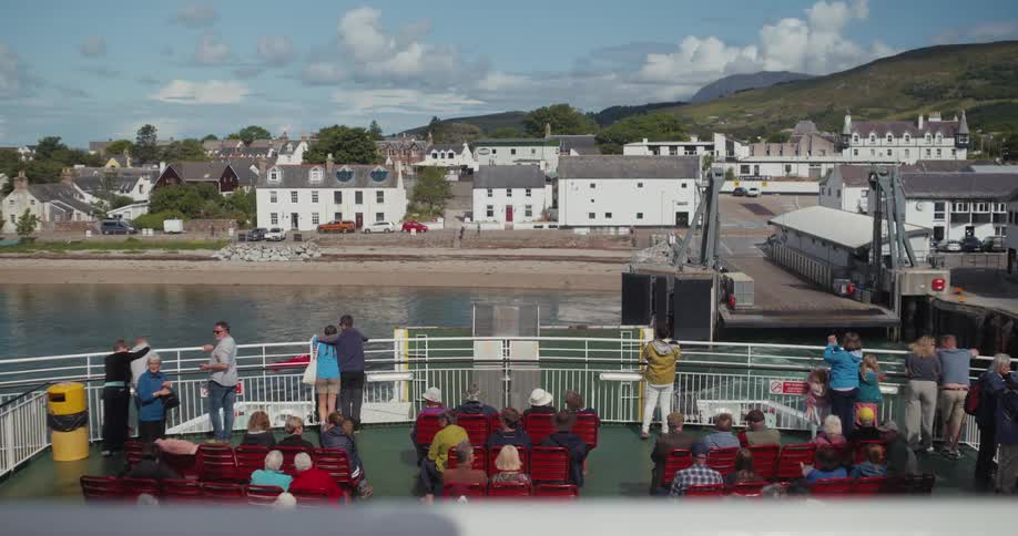 The ferry is full of people sitting and walking