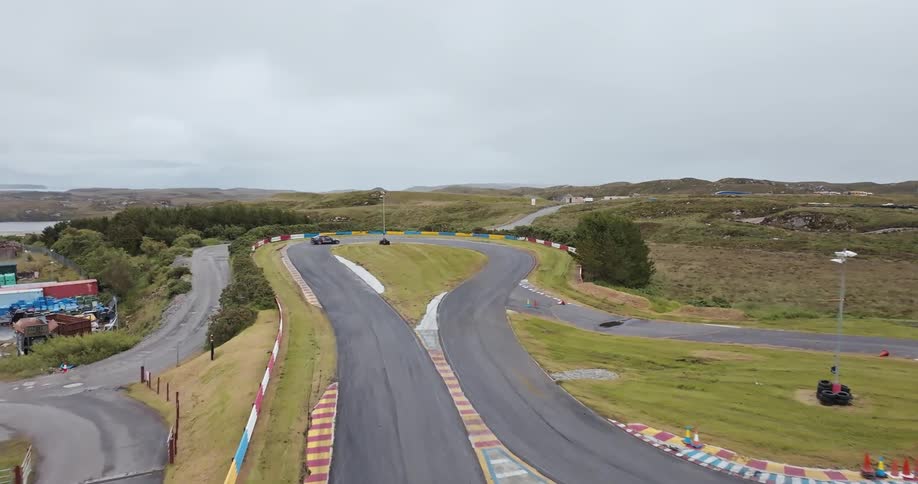 Car driving on a race track at top speed at midday