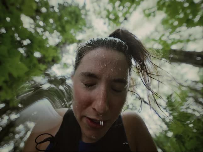 Portrait of a woman with a face dripping with sweat in a forest