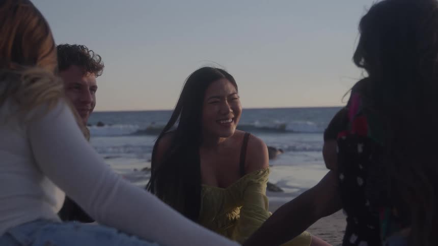 The friends talk together while sitting on the beach