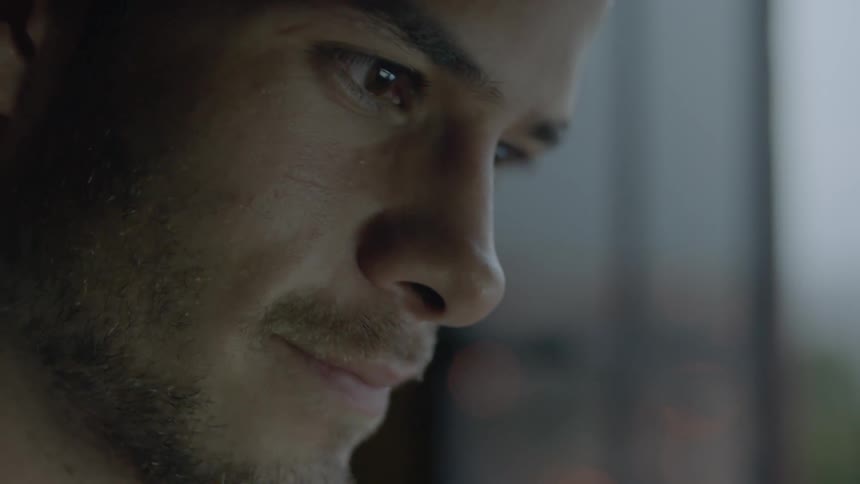 A man looks down smiling