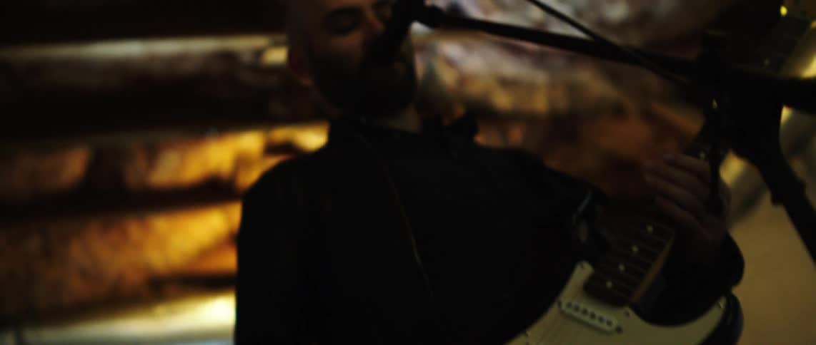 The musician sings and plays the guitar