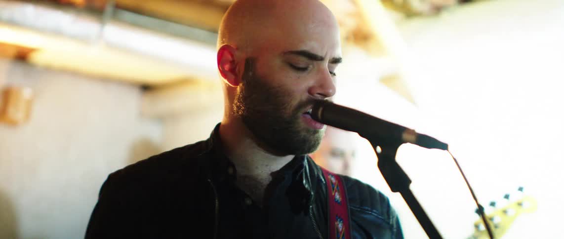 The band performs under flashing lights