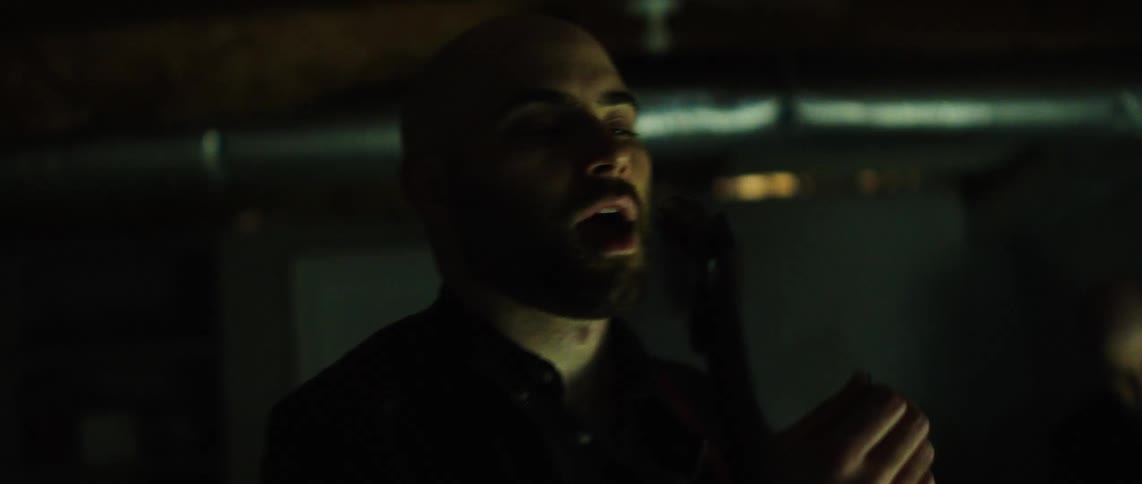 Bearded man singing into a microphone
