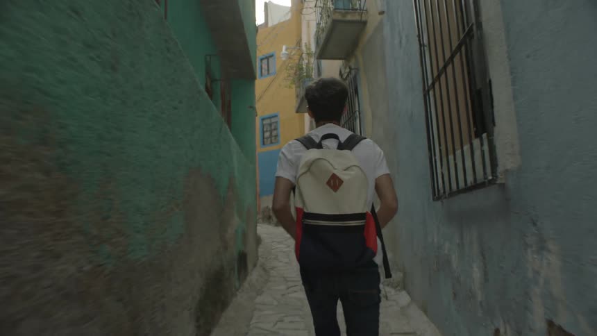 A man walks down an alley