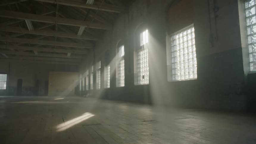 An empty warehouse with sunlight shining through windows