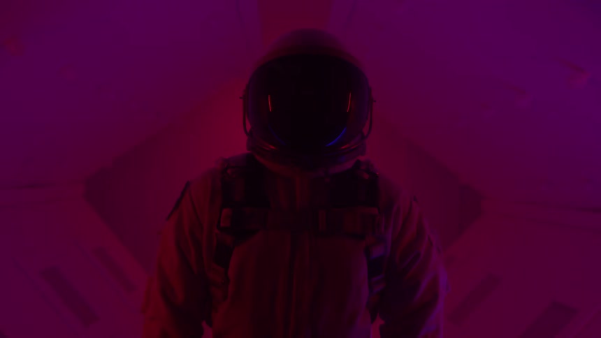 Person in spacesuit in a dimly lit hallway