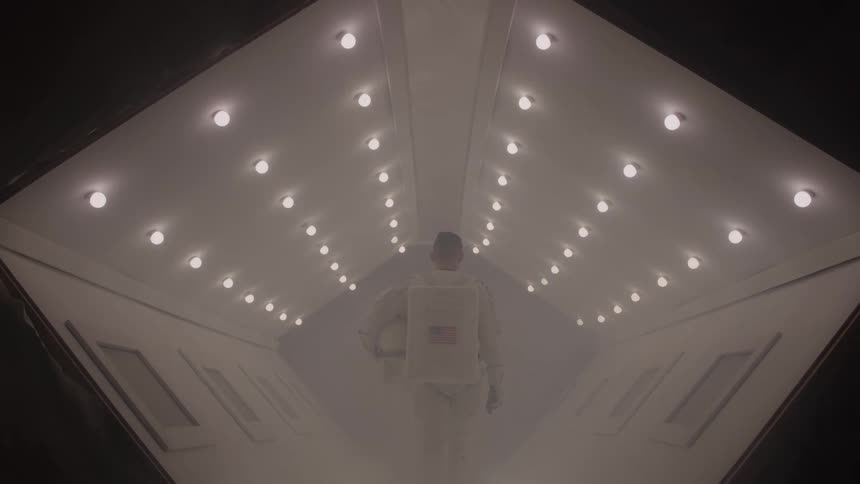 Person in spacesuit walking through tunnel with lights