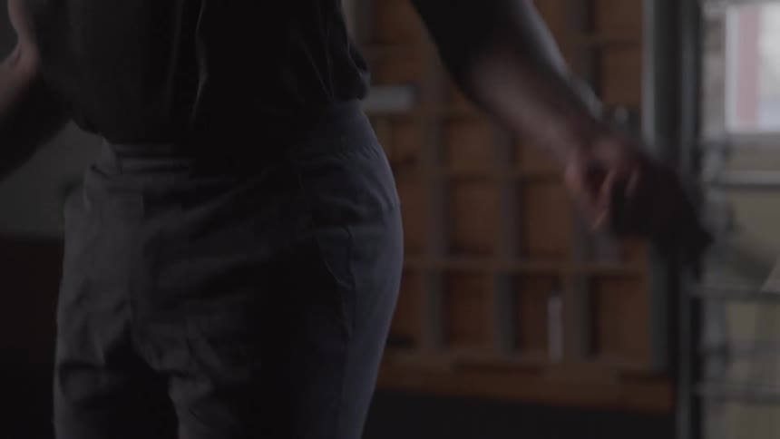 Young black man skipping rope inside a gym at midday wearing a black singlet