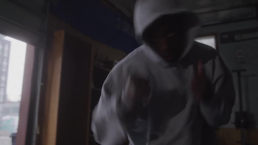 The man is shadow boxing and jumping around