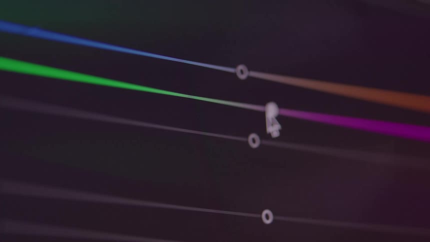 The video shows an abstract closeup shot of an editing software interface a cursor is seen adjusting a color curve which is represented by a line with multiple vibrant points of light that change in brightness
