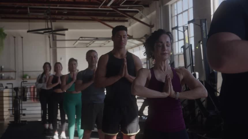 People are meditating together in the gym