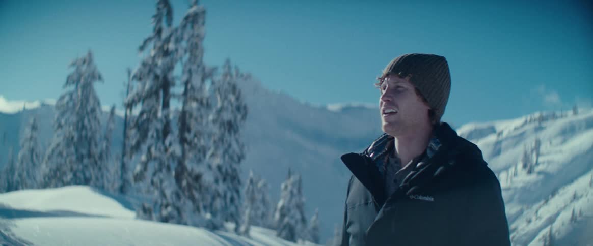 The video shows a man standing in a vast snowcovered landscape he smiles as he looks around taking in the beautiful peaceful winter scene