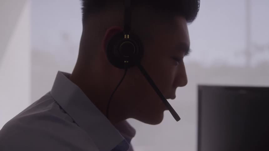 Side portrait of a man with headphones working