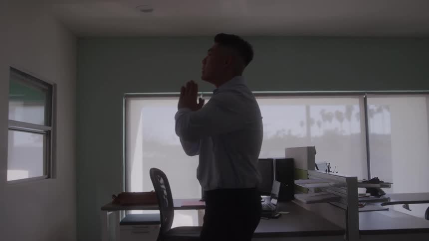 Man standing inside an office with a thoughtful expression