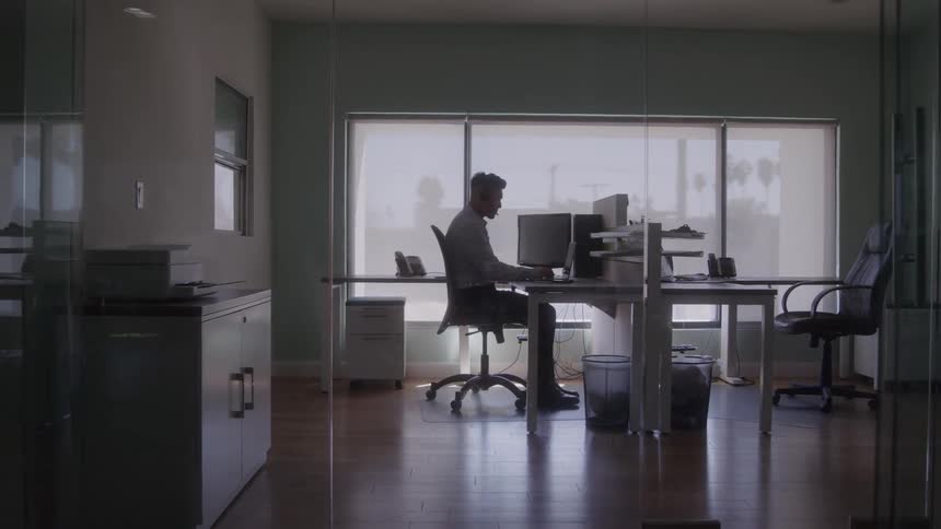 Man sitting in front of a computer in a bright office