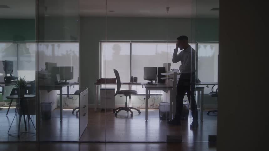 The man paces in the office while thinking