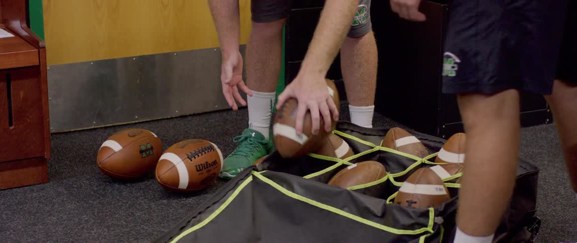 Two people selecting an american football