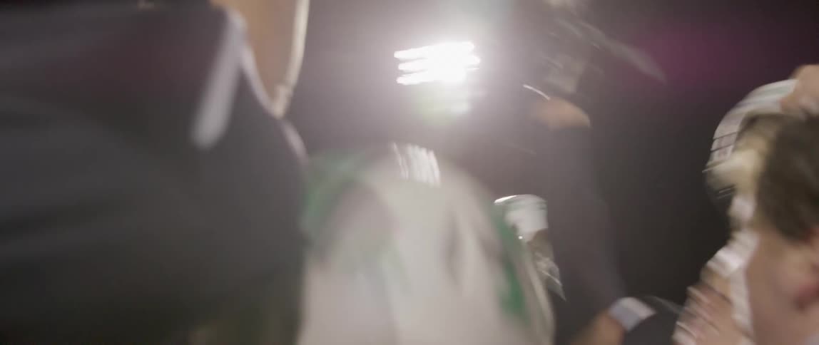 Football players cheer and raise their helmets