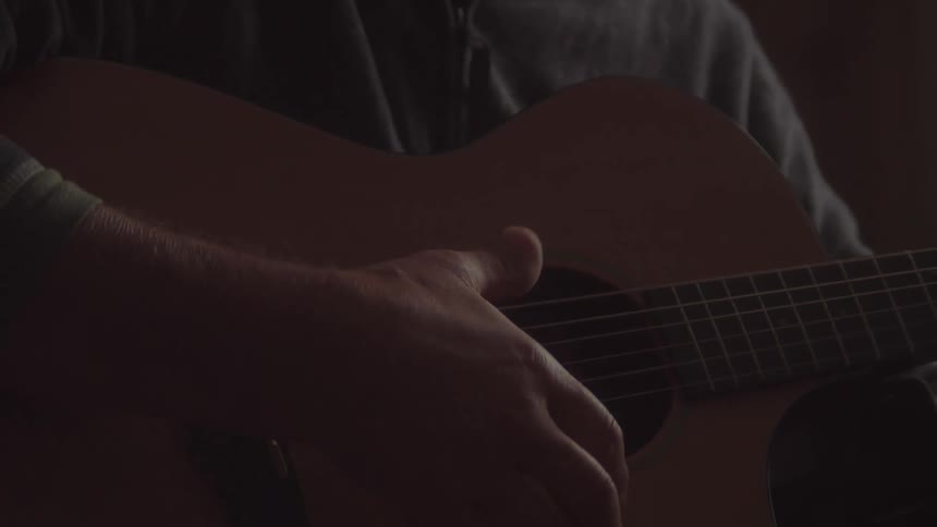 The man plays the guitar