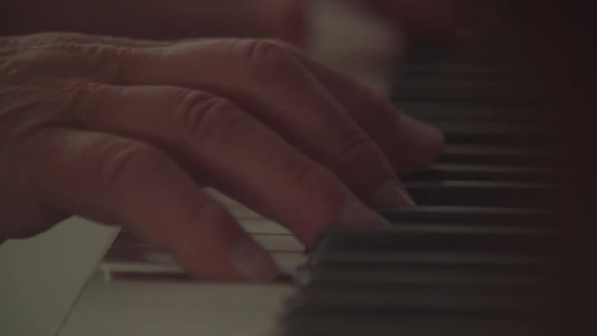 Hand playing piano keys