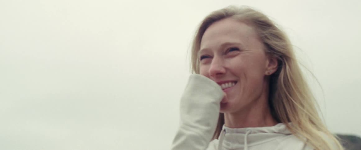 Smiling woman standing outside on a cloudy day