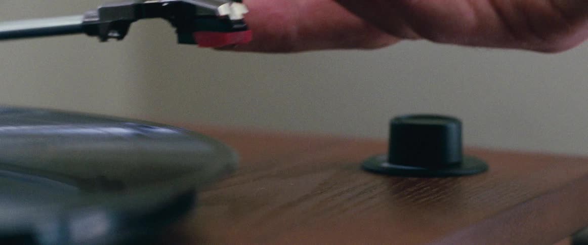 A person placing a needle on a record on a record player