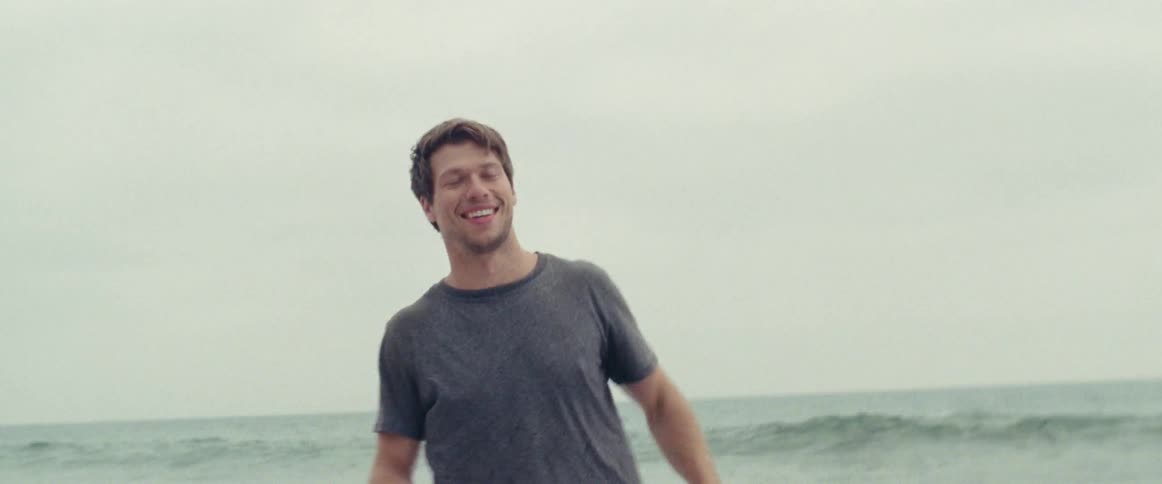 Man running on beach on a cloudy day