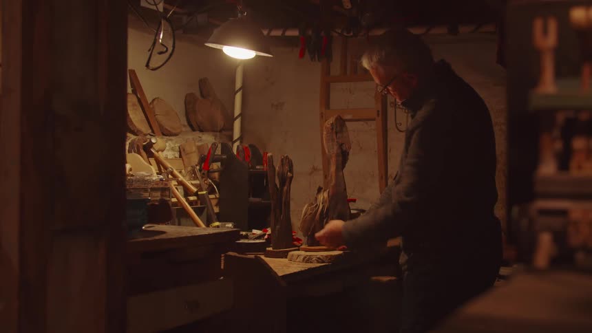 The woodworker is examining driftwood