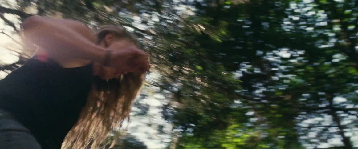 Woman leaping down from a log in the forest