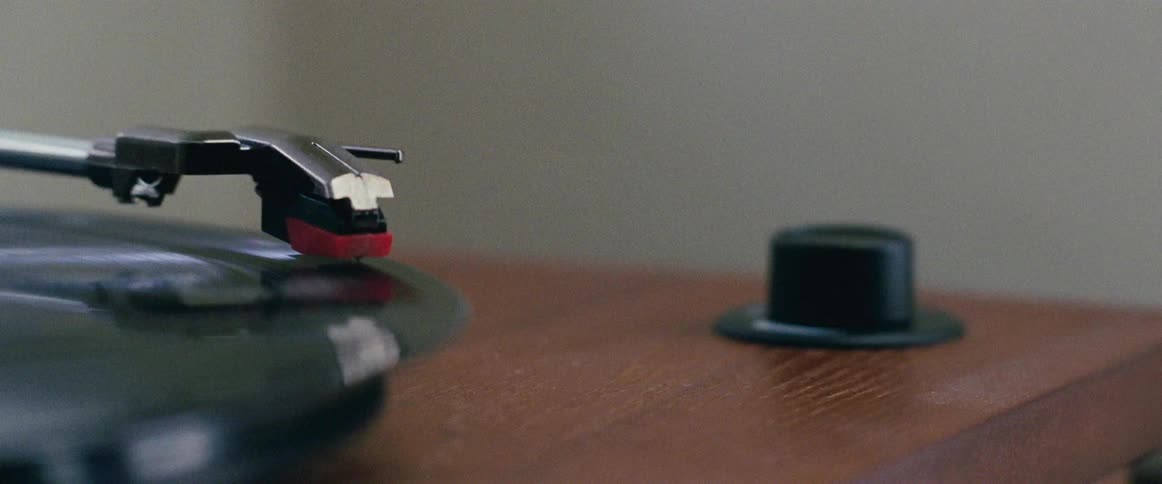 A close up view of a needle on a record playing and the record spinning