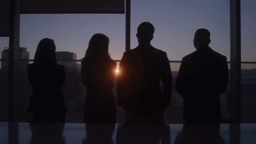 People are watching the sunrise through the building window