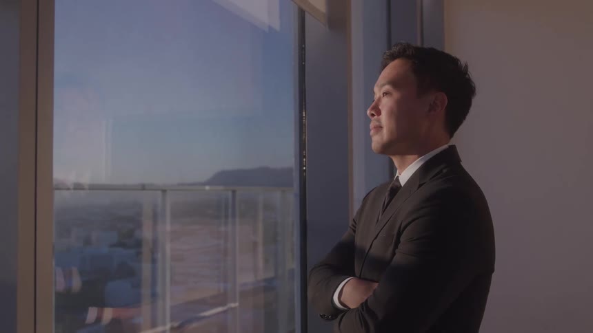 The man smiles while looking out the window