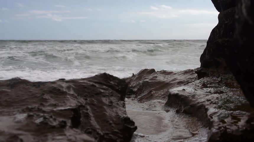 Rough beach with waves hitting the rocks