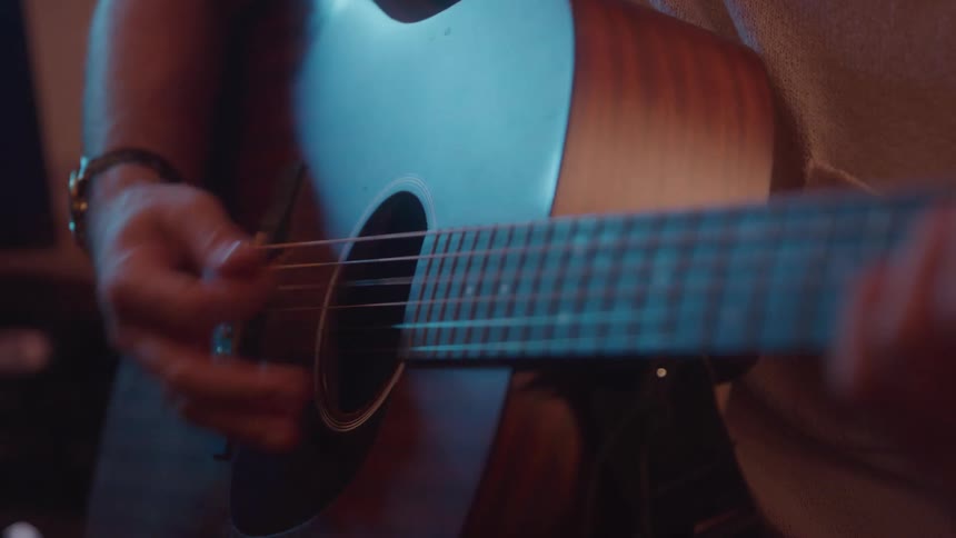 The man plays the acoustic guitar