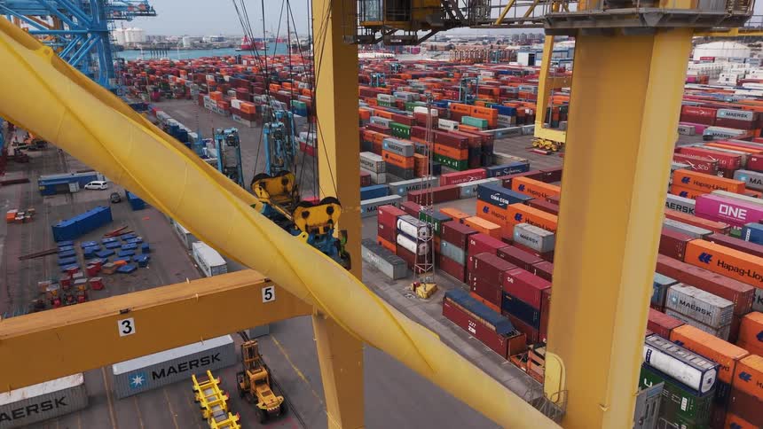A shipping container depot with piles and rows of containers cranes roads and forklifts