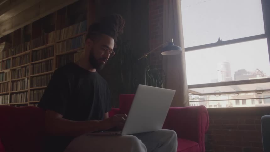 A man sitting on a sofa with a laptop