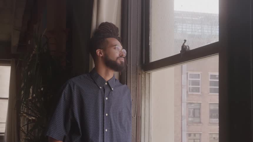 The man is looking out the building window