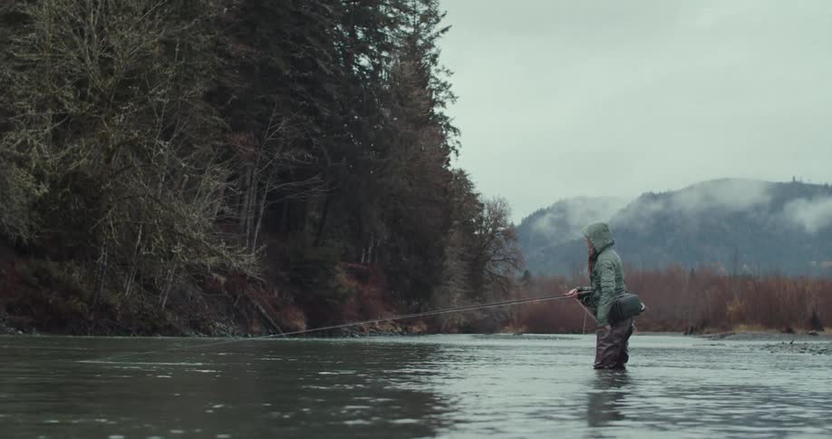 The man is fly fishing in the river