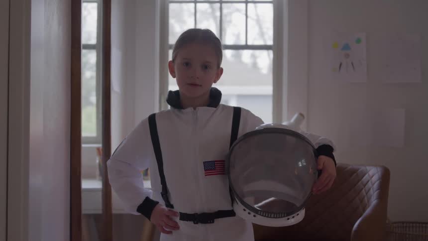 Child dressed as an astronaut holding a space helmet