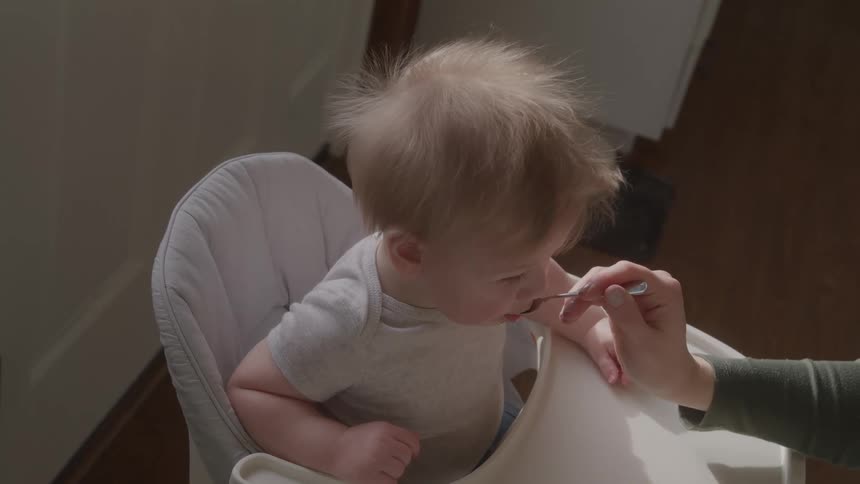A mother feeds her baby
