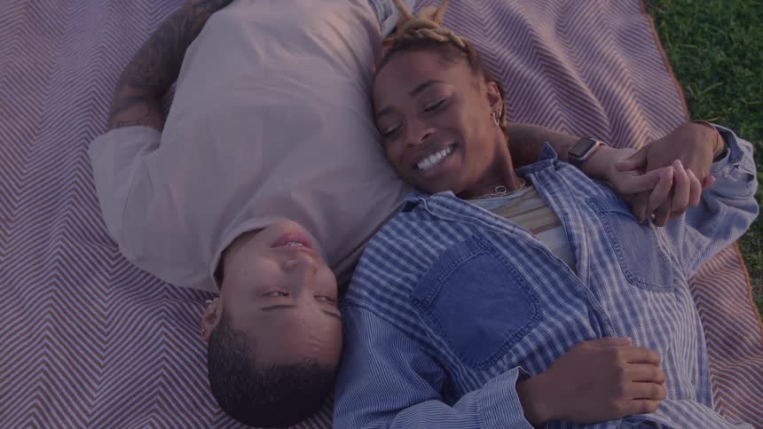 A couple relaxing on a blanket outside
